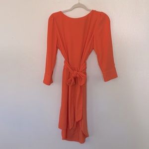 Emily McCarthy sherbet orange dress with oversized sash